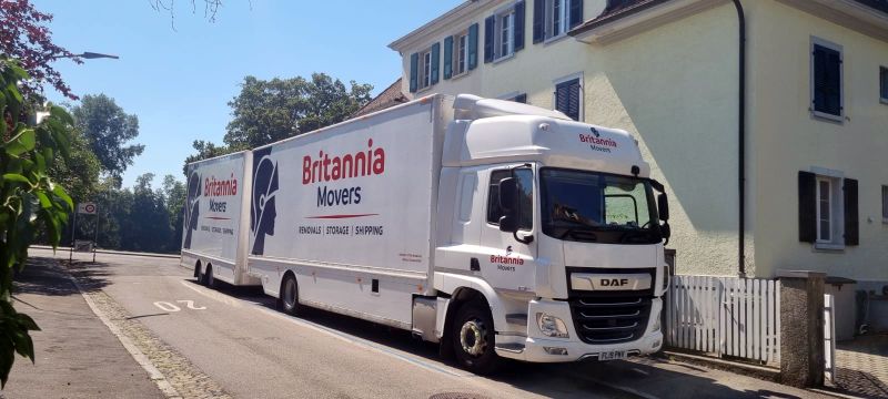 A Britannia-branded truck delivers to a house with French-style shutters during a move to the Channel Islands