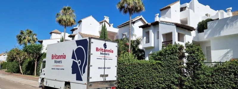 Britannia Robbins truck in a sunny suburban street with palm trees, carrying out a removal to Spain